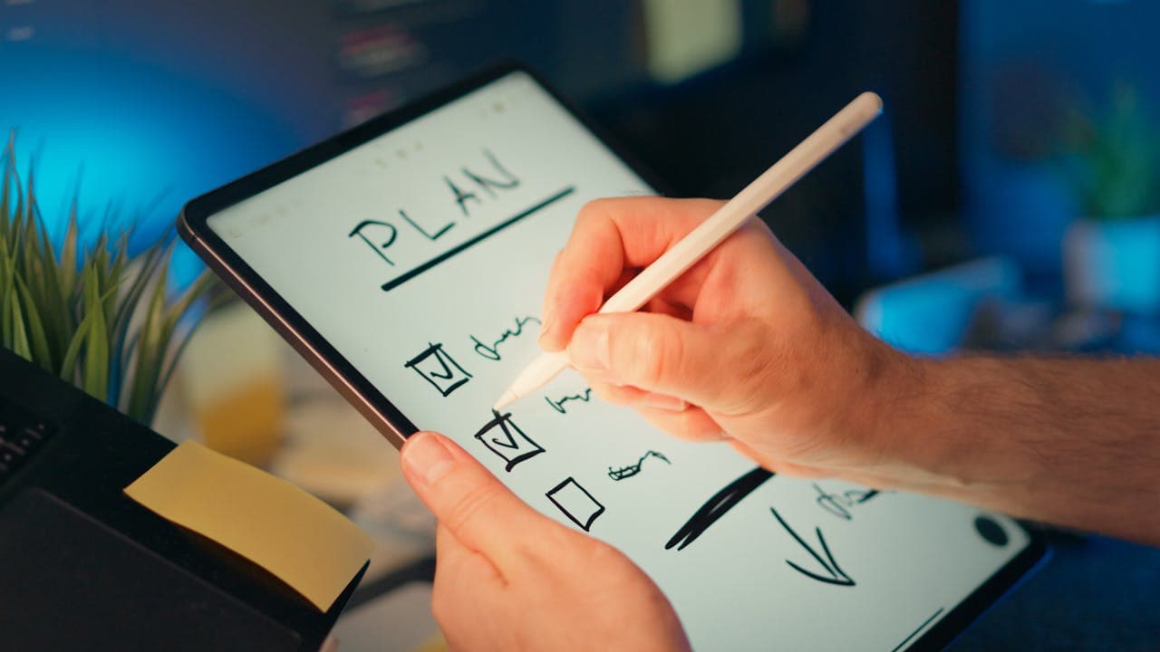 Person using a stylus on a tablet to review a digital planning checklist with task boxes