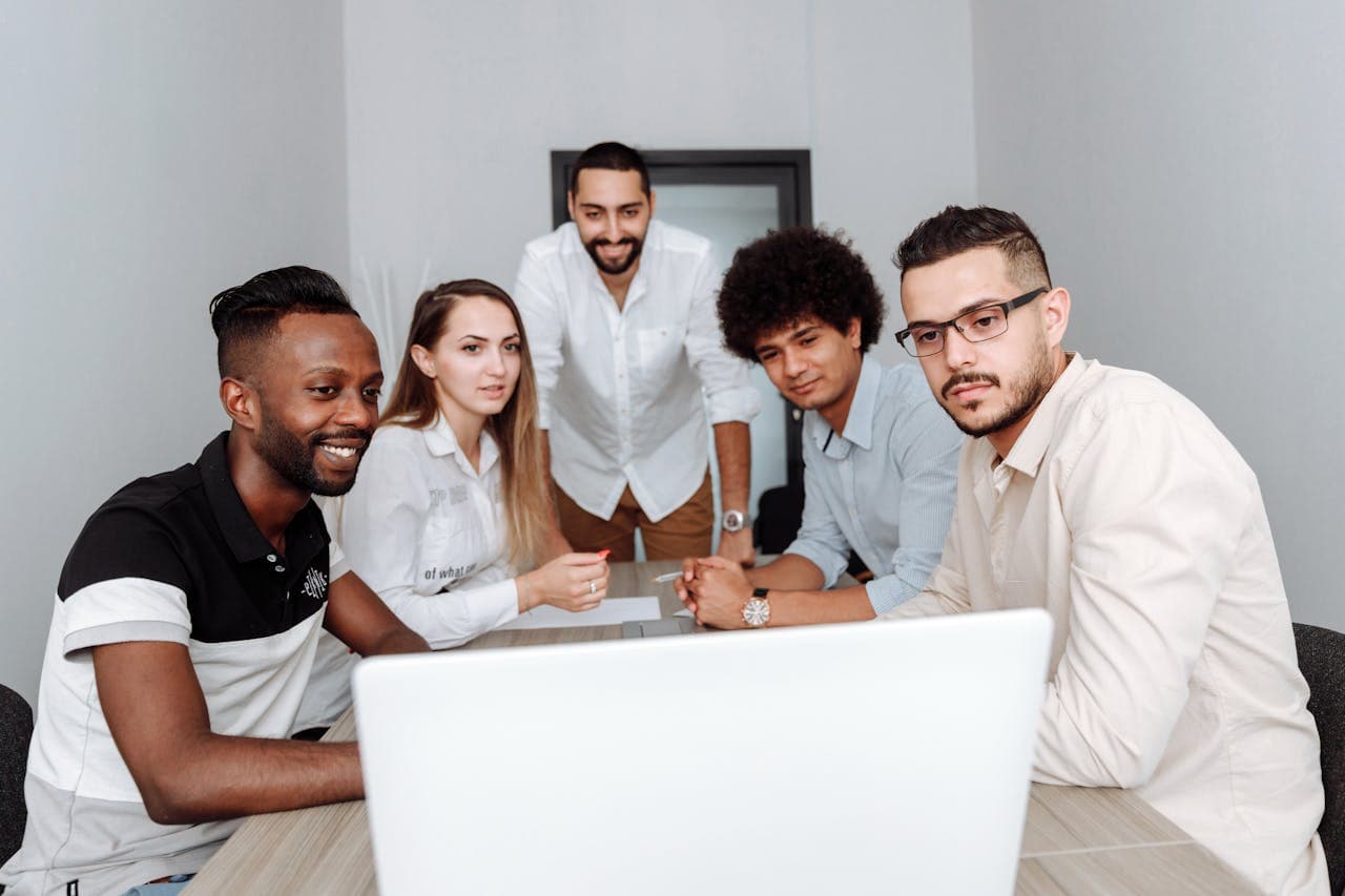 Business team gathered around a laptop during a meeting