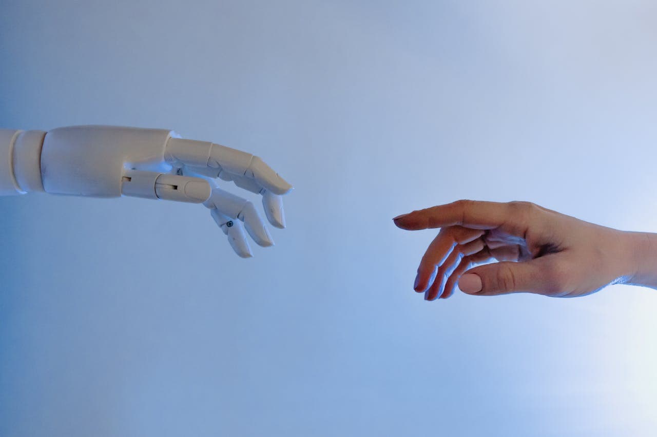 Robotic hand reaching toward a human hand against a minimalist background